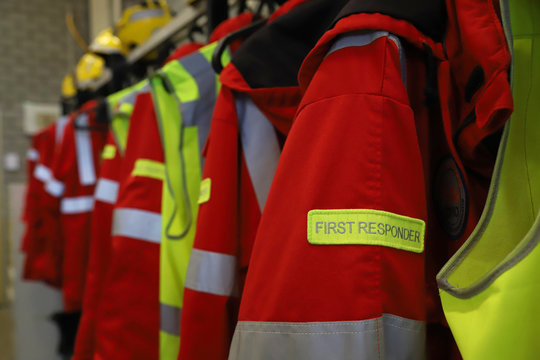 First responder jackets and high-visibility gear hanging on a station rack